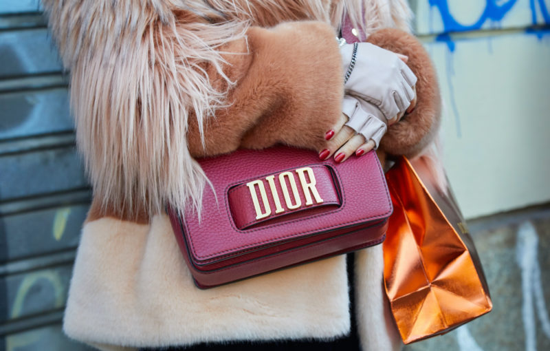 Woman with red leather Dior bag and brown pink fur coat before John Richmond fashion show, Milan Fashion Week street style