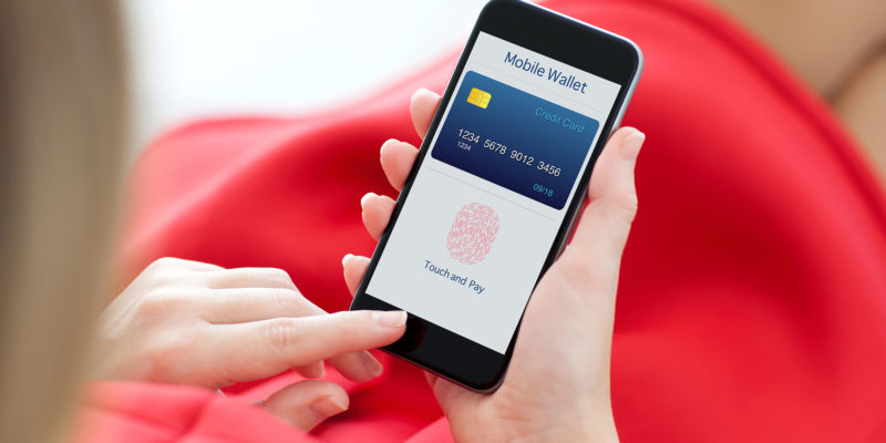 woman in red dress holding a phone with app mobile wallet and fingerprint for online shopping