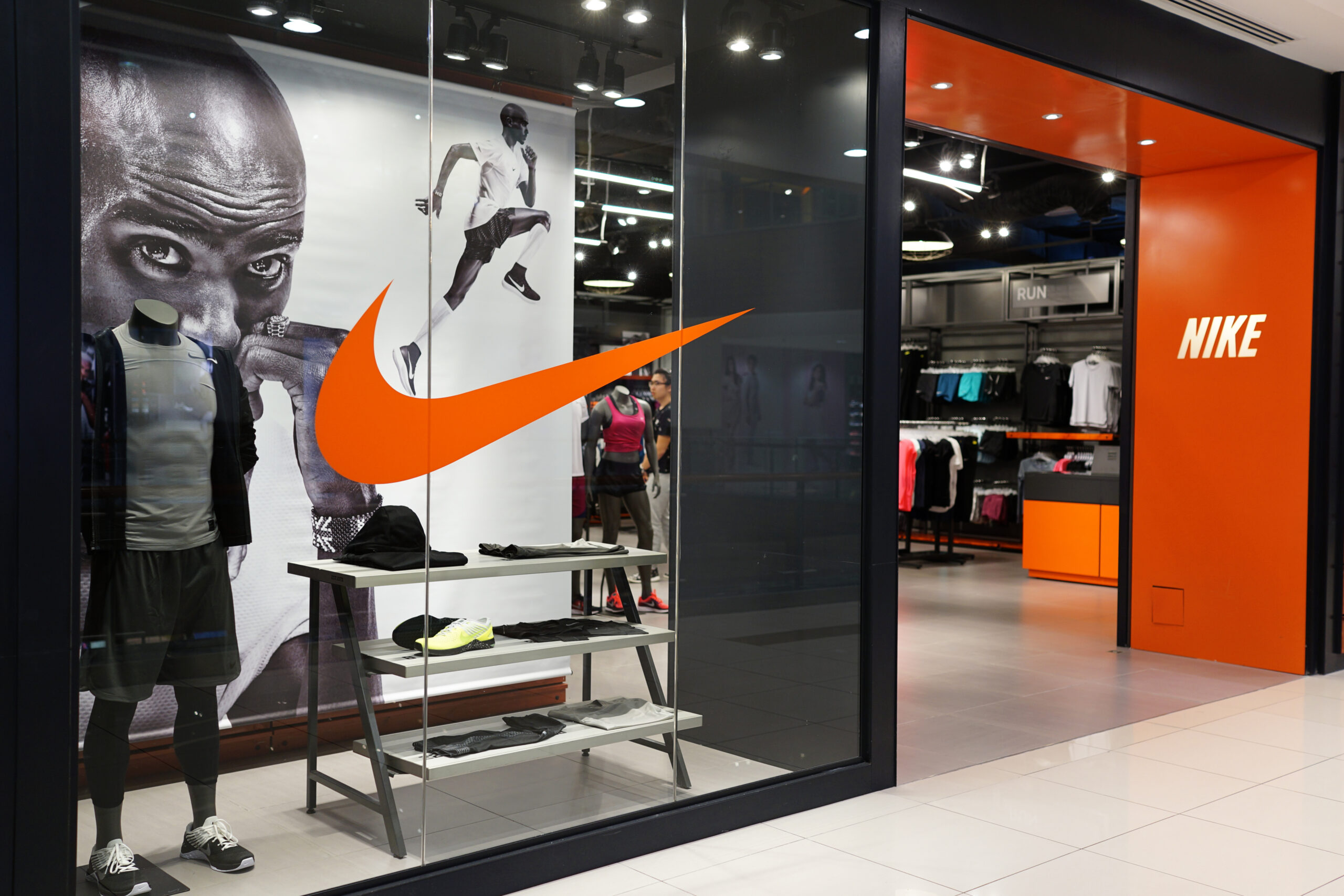 Black grey and orange photo of the front of a Nike store entrance