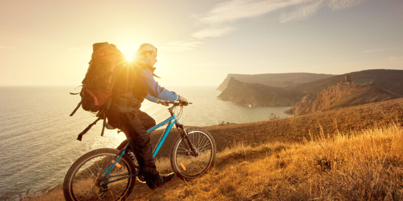 Photo of man Riding bike uphill into the sunset