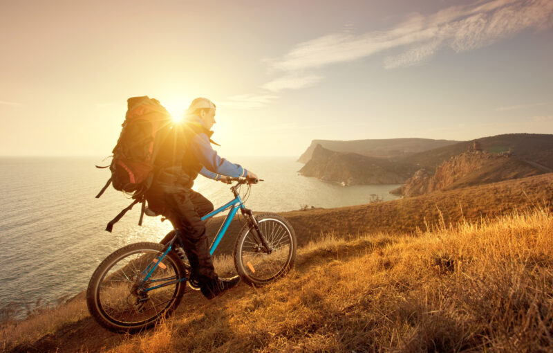 Photo of man Riding bike uphill into the sunset