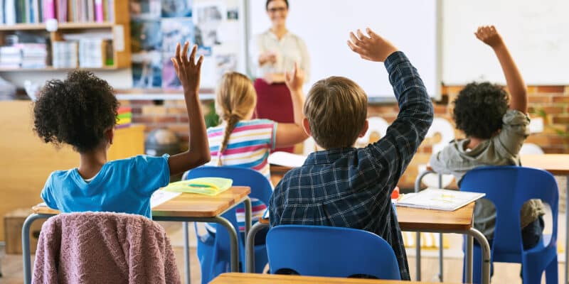 Children in school classroom learning about finance